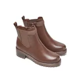 Bota de símil cuero color marrón, con elásticos laterales anchos para un mejor calce y cierre interno con tirador. Tiene punta redondeada, taco medio ancho y suela de goma con relieve antideslizante.