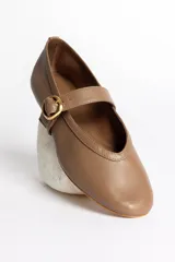 Ballerinas negras de cuero con tira sobre el empeine y hebilla dorada.