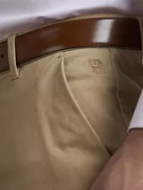 Pantalón de vestir azul marino, de corte slim fit, con bolsillos laterales y traseros. Se ajusta a la cintura con cinturón de cuero marrón.