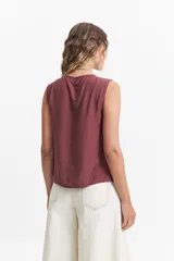 Blusa sin mangas color beige con lazo frontal y textura liviana.
