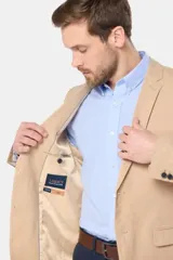 Saco azul de lino, corte clásico, con solapa de muesca, cierre de dos botones, bolsillo en el pecho y bolsillos laterales con solapa.