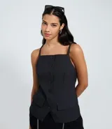 Chaleco femenino de sastrería color negro, con breteles finos y cierre frontal de botones. Diseño alargado con bolsillos falsos en la parte inferior.