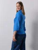 Camisa blanca de algodón marca Zac & Rachel, con cuello con solapa, abertura central con botones, delantera tableada y laterales elastizados.