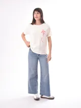 Remera color crudo con estampado de un pez rojo en el frente.