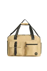 Bolso tipo duffel o de viaje color beige, con asas de mano y correa ajustable para hombro en color negro. Presenta múltiples bolsillos exteriores, incluyendo uno con tapa y hebilla de ajuste, y otro con cierre de cremallera.