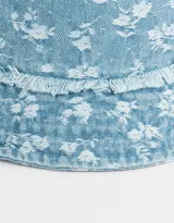 Piluso de denim celeste con estampado de pequeñas flores blancas y borde desflecado.