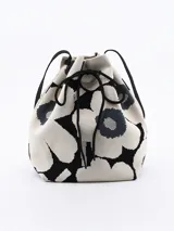 Bandolera tipo bucket con estampado de flores en blanco y negro, cierre con cordón ajustable y correa larga de hombro.