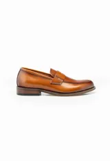 Mocasín de cuero color marrón claro, con antifaz y suela de cuero.