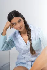 Pijama de algodón a rayas verticales celestes y blancas, compuesto por una camisa de manga larga con botones y un short con elástico en la cintura.