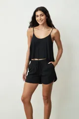 Musculosa negra con tirantes finos y corte holgado.