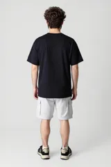 Remera negra de manga corta con estampado de dados y texto en el pecho.