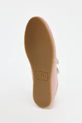 Zapato tipo bailarina deportiva color rosa con efecto satinado, puntera redondeada y doble tira con ajuste adhesivo.