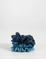 Set de tres scrunchies de tela de denim en diferentes tonos de azul con rayas blancas.