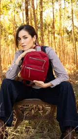 Mochila color beige de tafeta con doble apertura superior con cierre y tiradores metálicos. Incluye bolsillos internos, tres bolsillos con cierre metálico al frente y uno posterior. Asa corta de mano y correas para la espalda regulables.