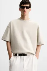 Sudadera relaxed fit color crudo confeccionada en tejido interlock de algodón con elasticidad, cuello redondo, manga corta y bajo acabado en rib.