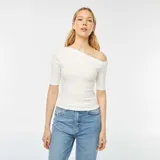 Camiseta blanca de manga corta con escote asimétrico que deja un hombro al descubierto.