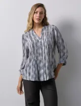 Blusa de gasa estampada con cuello a la base, escote en V y abertura central con botones. Delantera con plisados y mangas 3/4 regulables con presilla y botón.