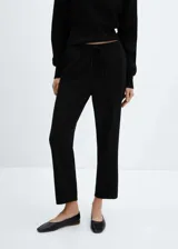 Pantalón negro de tejido fluido con diseño jogger, corte recto, tiro alto, bolsillos laterales, cintura elástica y cierre de cordón.