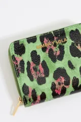 Monedero pequeño verde con estampado animal print en negro y rosa. Cierre con cremallera dorada y logo de la marca en el frente.
