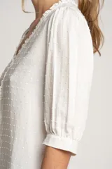 Blusa blanca de viscosa con escote en V, mangas 3/4 abullonadas y detalle de plumeti.