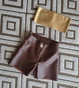 Short de cuero color marrón con botón y bolsillos delanteros.