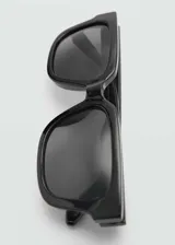 Lentes de sol negros con montura cuadrada de pasta y cristales grises.