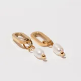 Aros colgantes dorados con forma de eslabón alargado y dije de perla colgando.
