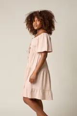 Vestido corto blanco con escote bardot, cintura fruncida y falda escalonada con vuelo.