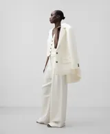 Pantalón de vestir de lino y viscosa color blanco, corte palazzo, con trabillas, pinzas delanteras, bolsillos laterales y bolsillos de vivo en la espalda.