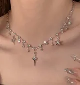 Collar plateado con cadena de eslabones y dijes colgantes de estrellas, cruces y strass.