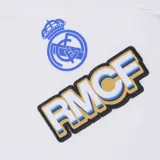 Remera blanca de manga corta con el escudo del Real Madrid y las siglas RMCE en el pecho.