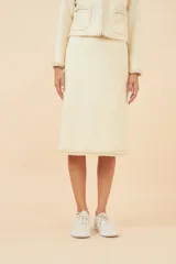 Falda midi de lana color gris con textura tweed y corte recto. Presenta un galón tejido marrón en el ruedo y forro al tono.