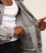 Campera trucker boxy de jeans gris con cuello de terciopelo negro, abotonada al frente, con bolsillos delanteros y mangas largas ajustadas.
