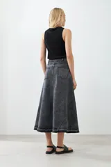 Maxi falda de jean gris oscuro con diseño de paneles y cinturón con hebillas plateadas.