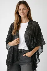 Poncho negro de tejido de red con lentejuelas, de corte asimétrico y mangas cortas.