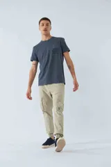 Pantalón cargo color marrón con corte slim, elástico en cintura y cordón ajustable, bolsillos cargo con botones y puños elásticos. Confeccionado en algodón y spandex.