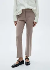 Pantalón de vestir color beige, de corte recto y largo a la altura del tobillo.