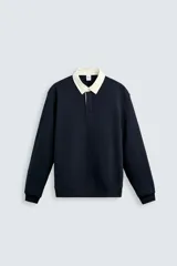 Sudadera azul marino de corte recto, con cuello polo blanco y tapeta con botones oculta.