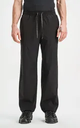 Pantalón negro de tejido técnico impermeable, corte recto y holgado, con elástico en cintura y puños. Presenta cordones ajustables con estampado repetitivo en la bragueta y un pequeño parche cuadrado con un logo de tijeras en el muslo derecho.