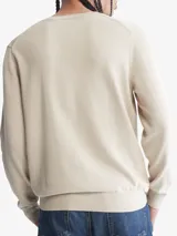 Sweater de algodón color beige, de cuello redondo y corte clásico. Presenta el logo de la marca bordado en el pecho.