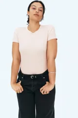 Remera color rosa claro en tejido acanalado de algodón, corte entallado, cuello redondo con ribete fino y bajo recto.