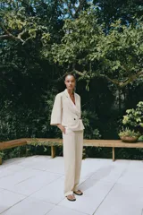Pantalón de vestir color beige, de tiro alto, con cintura elástica en la parte trasera, bolsillos delanteros y falsos bolsillos de vivo en la parte trasera.
