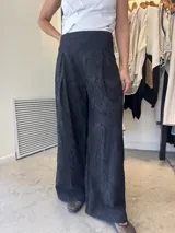 Pantalón palazzo negro con textura floral en relieve.