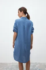 Vestido camisero celeste de lino con cuello clásico, abotonadura frontal y mangas 3/4 con trabillas.