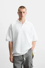 Polo blanco de piqué con corte relaxed fit, cuello solapa y cierre frontal con botones.