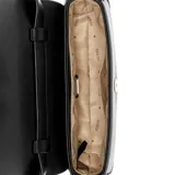 Bandolera Guess color negro con correa fina ajustable y logo triangular metálico en el frente.