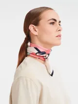 Pañuelo de seda Longchamp modelo University, con estampado geométrico en tonos rosa, beige, azul y negro.