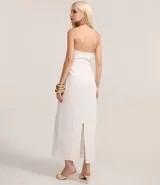 Vestido midi blanco sin breteles, confeccionado en bengalina. Presenta adornos en el busto y recorte cutout en la cintura.