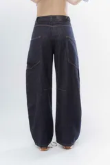 Jean wide leg color marrón, con corte recto y amplio, y costuras protagonistas que crean un diseño geométrico en las piernas.