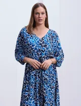 Vestido corto de rayón con estampado floral en tonos azules y blancos. Tiene escote en V, mangas 3/4 con puño, cintura con lazo de ajuste y borlas.